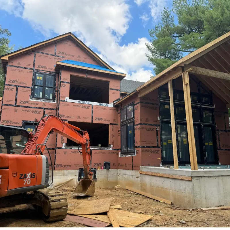 Two-story home addition wrapped in ZIP System sheathing with excavator on site