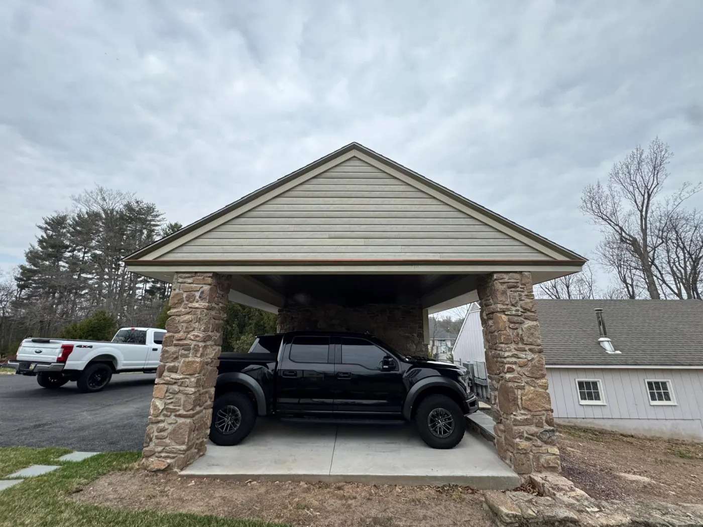 Finished stone carport with new gable roof and original masonry columns