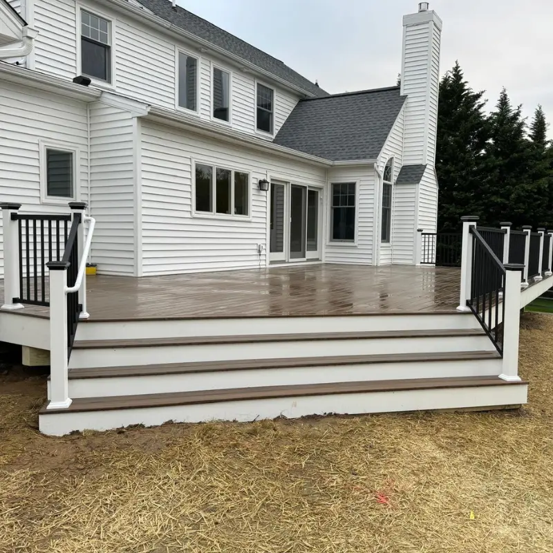 Finished composite deck with white posts and black metal railings